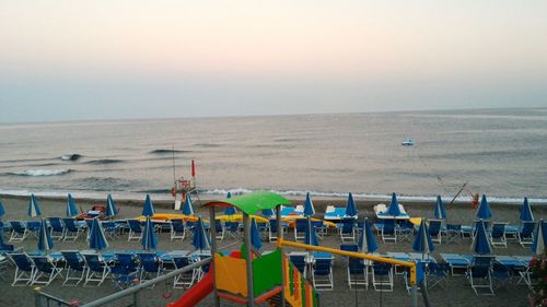 Chairs on beach against clear sky