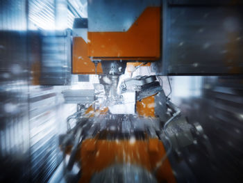 Cnc machine splashing water while cutting material inside modern factory