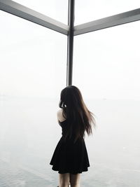 Woman standing by sea against clear sky