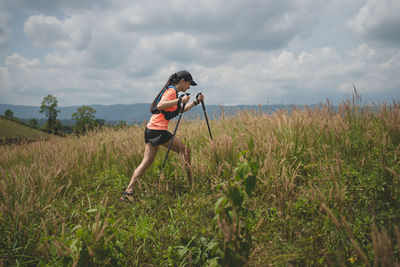 Full length of woman standing on field against sky