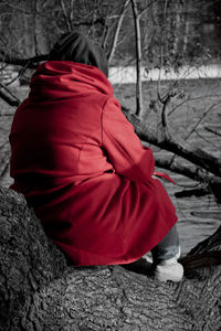 Rear view of woman sitting on snow