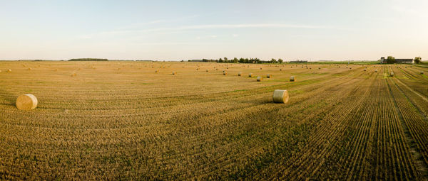 Hay bales on field against sky