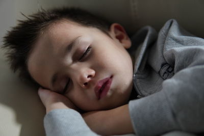 Close-up of baby sleeping on bed at home