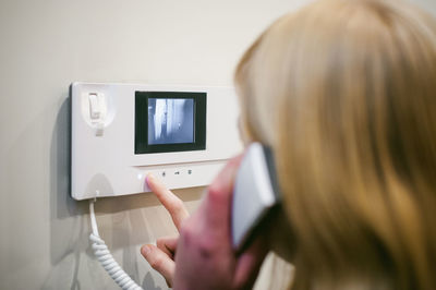 Close-up of woman talking on intercom