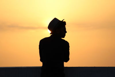 Silhouette man standing at sunset