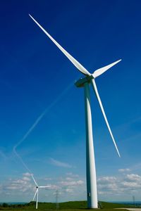 Low angle view of windmill against blue sky