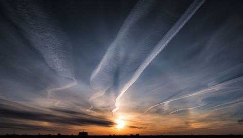 Scenic view of vapor trail against sky during sunset