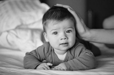 Portrait of cute baby lying on bed