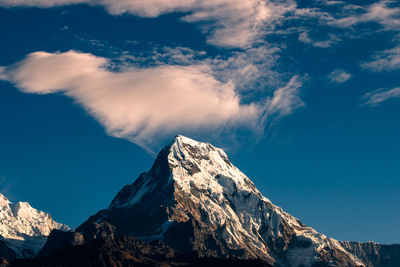 Low angle view of snowcapped mountains against sky