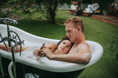 High angle view of man and woman lying down in water