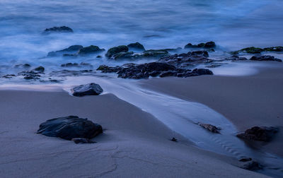 Rocks on beach against sky