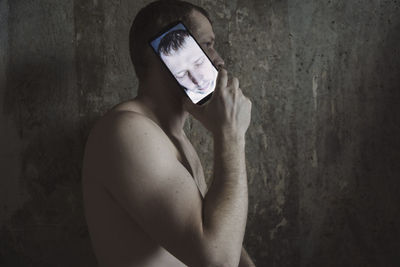 Portrait of young man standing against wall