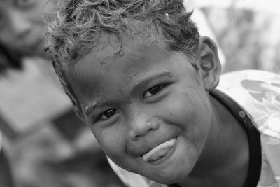 Close-up portrait of cute boy sticking out tongue