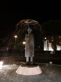 Illuminated statue against sky at night