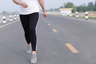 Low section of woman running on road