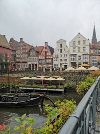 Canal amidst buildings in city against sky