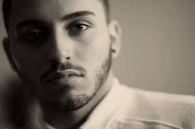 Close-up portrait of young man against wall