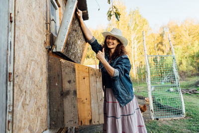 Portrait of young woman standing against wall