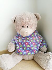 High angle view of teddy bear sitting on floor against wall