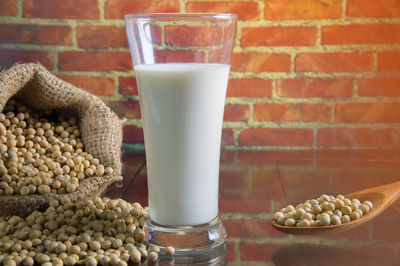 Close-up of milk by grains on table