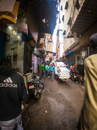 Rear view of people walking on street in city