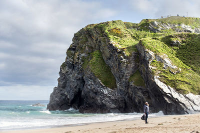 Man standing at beach against mountain