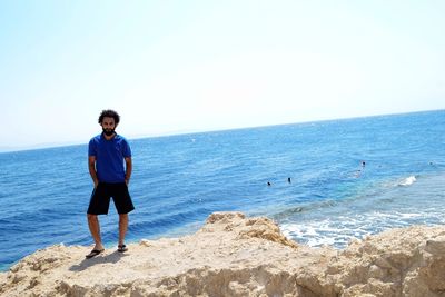 Full length of man standing on beach against sky