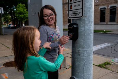 Sisters playing with buttons at a stop light