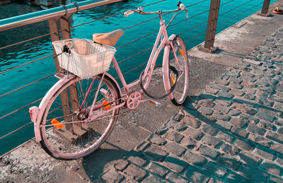 Pink bicycle by river on bridge