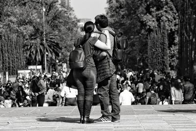 Rear view of couple walking on street in city