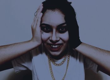 Close-up portrait of young woman against white background