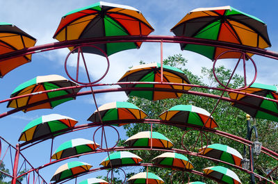 Low angle view of multi colored umbrellas against sky