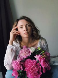 Portrait of beautiful woman holding pink flower