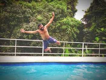 Mid adult man diving into swimming pool