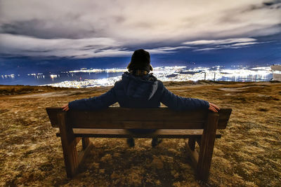 Rear view of man sitting on bench