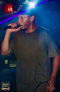 Midsection of man with arms raised standing at music concert