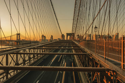 Suspension bridge against sky during sunset