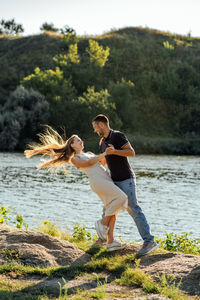 Declarations of love, candid couple in love holding hands on nature background.