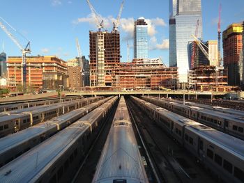 Railroad tracks amidst buildings in city against sky