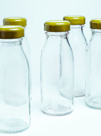 Close-up of empty glass bottle against white background