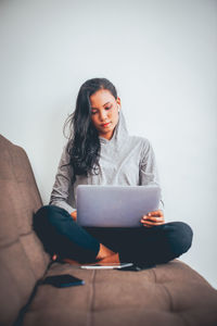 Young woman using mobile phone at home