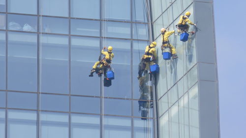 Low angle view of workers cleaning modern office building