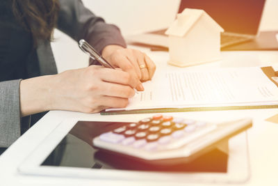 Close-up of hands holding cup and table
