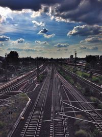 Railroad tracks against cloudy sky