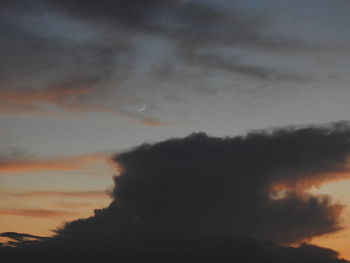 Low angle view of silhouette trees against dramatic sky