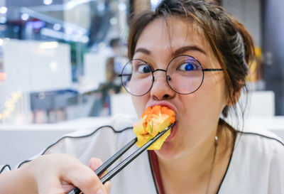 Close-up portrait of woman eating food at restaurant