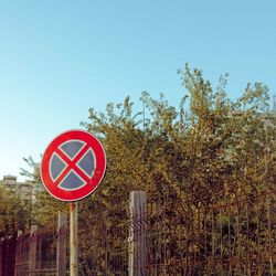 Road sign against clear blue sky