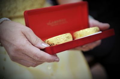 Midsection of woman holding gold bangles