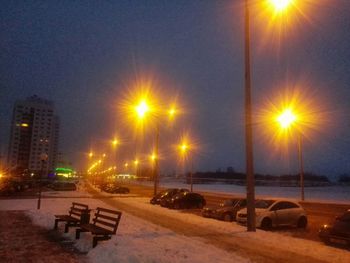 Illuminated street light against sky