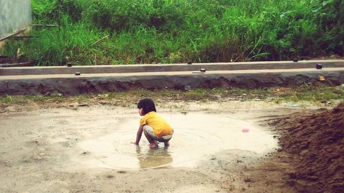 Rear view of man working in water